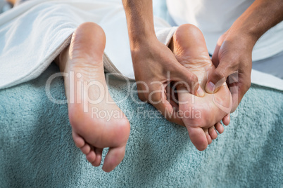 Physiotherapist giving foot massage to a woman