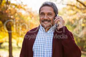 Mature man talking on mobile phone at park