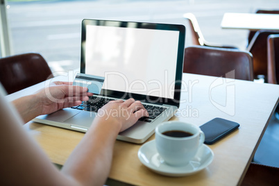 Woman making online payment in coffee shop
