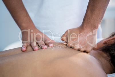 Physiotherapist giving back massage to a woman
