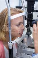 Optometrist examining female patient on slit lamp