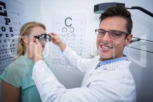 Optometrist examining female patient with phoropter
