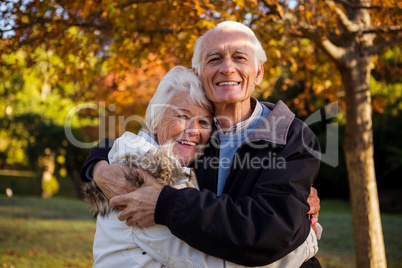 Happy senior couple embracing at park