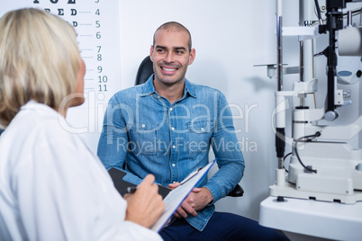 Female optometrist talking to male patient