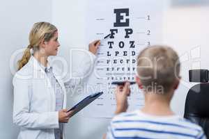 Female optometrist taking eye test of young patient