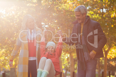 Happy daughter playing with parents at park