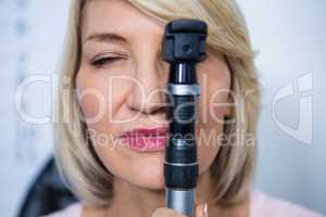 Female patient looking through ophthalmoscope