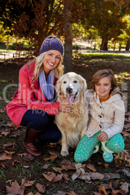 Mother and daughter caressing their dog