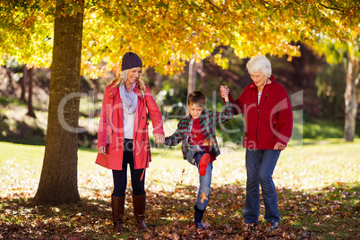 Happy boy walking with mother and grandmother