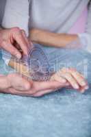 Physiotherapist measuring patient hand with goniometer