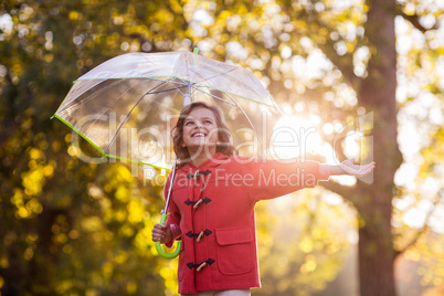 Smiling girl with umbrella at park