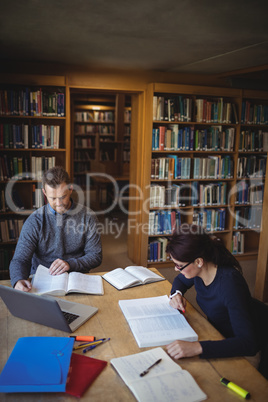 Mature students working together in college library