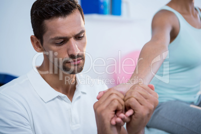 Physiotherapist giving hand massage to a woman