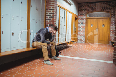Stressed mature student sitting in locker room Stressed mature student sitting in locker room