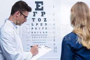 Optometrist writing on clipboard