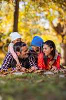Cheerful family lying on field during autumn
