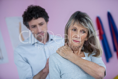 Physiotherapist giving neck massage to female patient