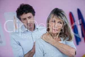 Physiotherapist giving neck massage to female patient