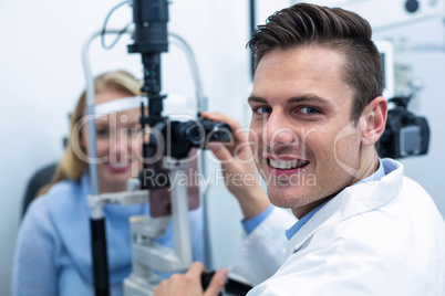 Optometrist examining female patient on slit lamp