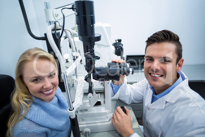 Optometrist examining female patient on slit lamp