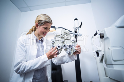 Female optometrist adjusting phoropter
