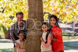 Portrait of smiling family standing by tree