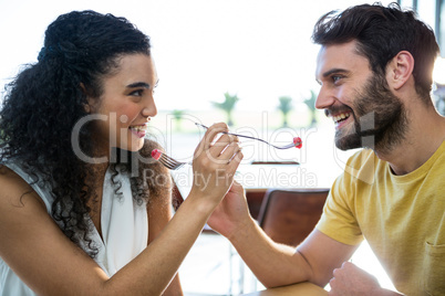 Couple feeding each other dessert in coffee shop
