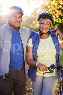 Portrait of mature couple holding cycling helmet