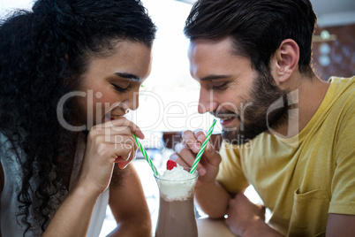 Couple having milkshake in coffee shop