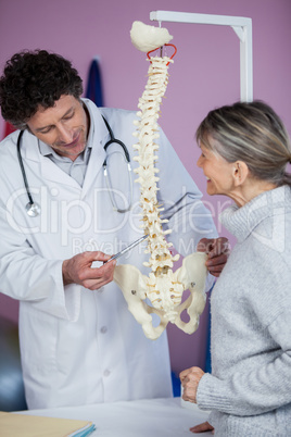 Physiotherapist explaining the spine model to patient