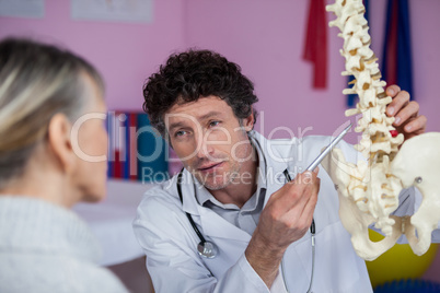 Physiotherapist explaining the spine model to patient