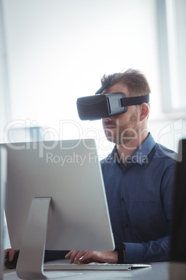 Mature student in virtual reality headset using computer