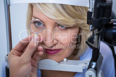 Female patient under going eye test on slit lamp