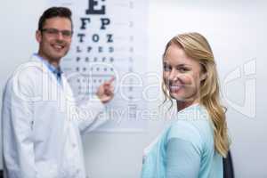 Optometrist taking eye test of female patient