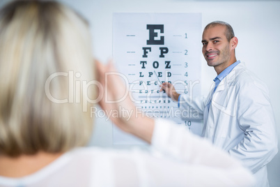 Male optometrist taking eye test of female patient