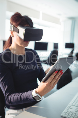 Mature student in virtual reality headset using digital tablet