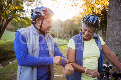 Man pointing his smart watch front of his wife