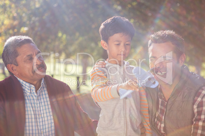 Boy playing with toy airplane by family