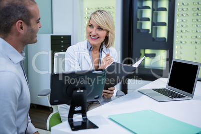 Female optometrist talking to male patient