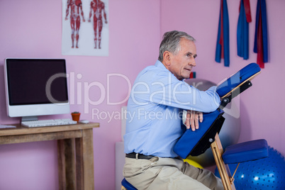 Senior man sitting on massage chair