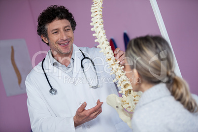 Physiotherapist explaining the spine model to patient