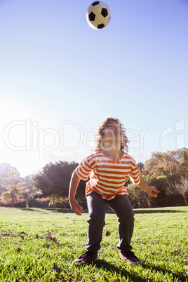 Boy playing with soccer ball in park