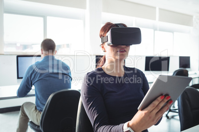 Mature student in virtual reality headset using digital tablet