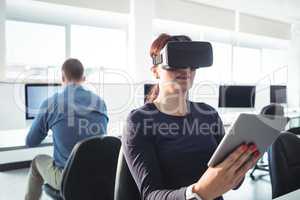 Mature student in virtual reality headset using digital tablet