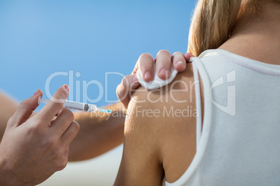 Physiotherapist injecting female patient
