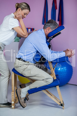 Physiotherapist giving back massage to a patient