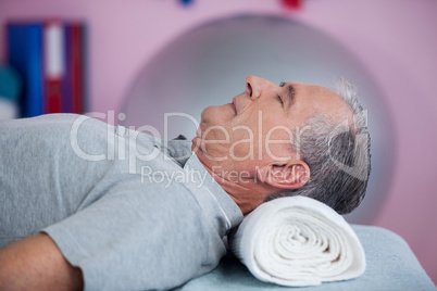 Senior man lying on a massage bed