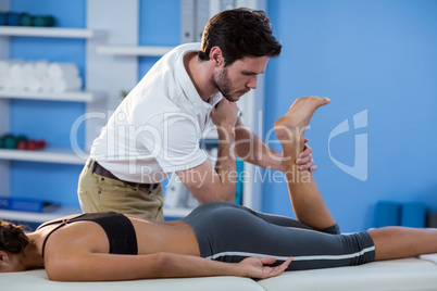 Male physiotherapist giving hip massage to female patient