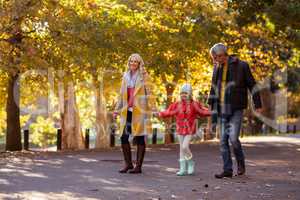 Girl walking with parents on road