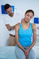 Physiotherapist giving neck massage to female patient